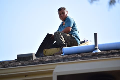 worker replacing residential roof